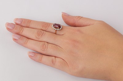 Lot 24 - A ruby and diamond cluster ring