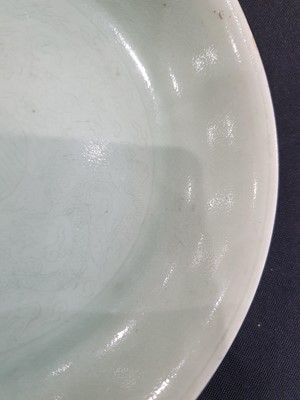Lot 568 - A CHINESE INCISED CELADON 'DRAGONS' DISH.
