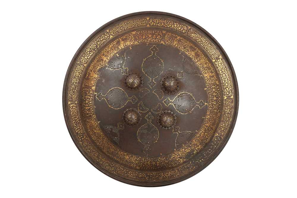 Lot 118 - A QAJAR GOLD-DAMASCENED STEEL SHIELD WITH OPENWORK MEDALLIONS