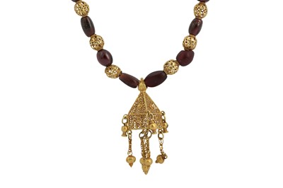 Lot 167 - A GARNET BEAD NECKLACE WITH GOLD FILIGREE PENDANT