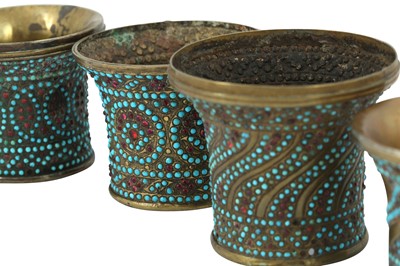Lot 147 - FOUR GLASS BEAD AND TURQUOISE-SET BRASS QALYAN CUPS