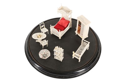 Lot 170 - A 19TH CENTURY CARVED BONE SET OF MINIATURE FURNITURE WITHIN A GLASS DOME