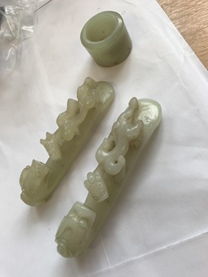 Lot 307 - TWO CHINESE PALE CELADON JADE BELT HOOKS AND AN ARCHER'S RING.
