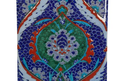 Lot 512 - AN IZNIK-STYLE KUTAHYA POTTERY TILE WITH ARABESQUE AND FISH-SCALE MOTIF