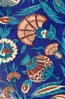 Lot 513 - AN IZNIK-STYLE KUTAHYA POTTERY TILE WITH POMEGRANATE AND CARNATIONS