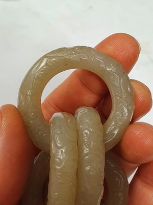 Lot 917 - FOUR CHINESE CARVED WHITE JADE CONJOINED RINGS.