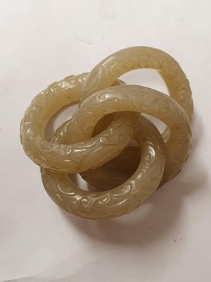 Lot 917 - FOUR CHINESE CARVED WHITE JADE CONJOINED RINGS.