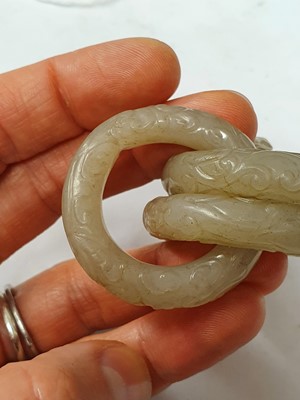 Lot 917 - FOUR CHINESE CARVED WHITE JADE CONJOINED RINGS.