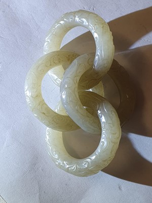 Lot 917 - FOUR CHINESE CARVED WHITE JADE CONJOINED RINGS.