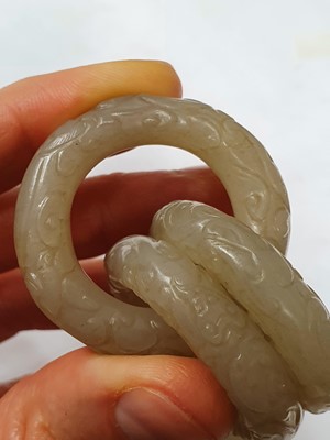 Lot 917 - FOUR CHINESE CARVED WHITE JADE CONJOINED RINGS.