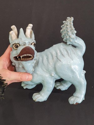 Lot 706 - A PAIR OF CHINESE PALE BLUE GLAZED MODELS OF MYTHICAL BEASTS.