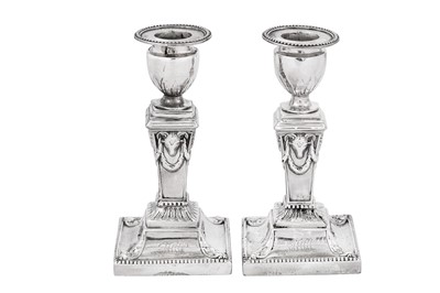 Lot 654 - A pair of George III sterling silver dwarf or desk candlesticks, Sheffield 1776 by J Hoyland & Co, overstruck for London by Robert Jones and John Scofield (reg. 10th February 1776)