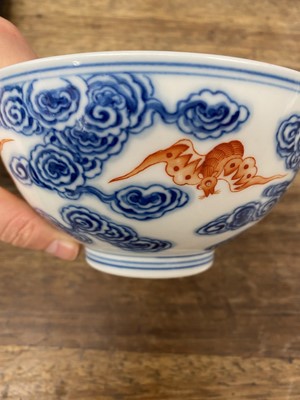 Lot 214 - A CHINESE BLUE AND WHITE AND IRON-RED 'BATS AND CLOUDS' BOWL.