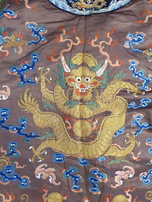 Lot 289 - A CHINESE CHESTNUT-GROUND EMBROIDERED 'DRAGON' ROBE.