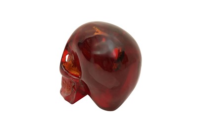Lot 208 - A MID-20TH CENTURY AMBER-TYPE CARVED REDUCTION OF A HUMAN SKULL