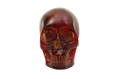 Lot 208 - A MID-20TH CENTURY AMBER-TYPE CARVED REDUCTION OF A HUMAN SKULL