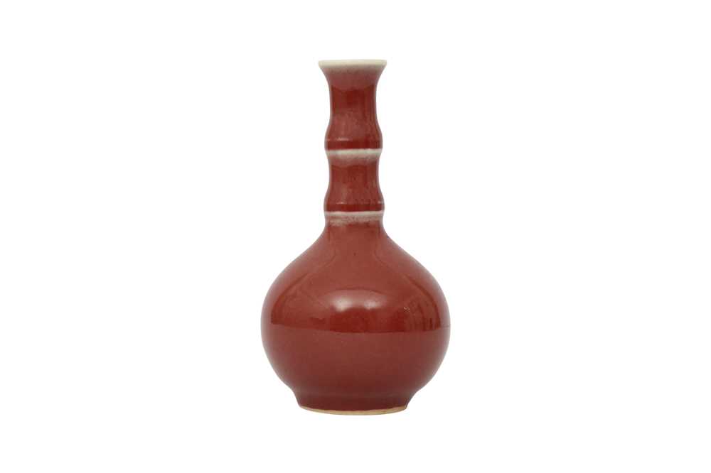 Lot 47 - A SMALL CHINESE SANG-DE-BOEUF BOTTLE VASE.