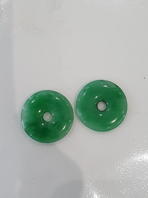 Lot 191 - A PAIR OF SMALL CHINESE APPLE-GREEN JADEITE PENDANTS.