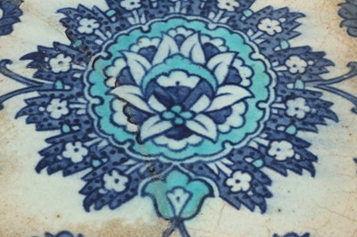 Lot 320 - A BLUE AND WHITE IZNIK POTTERY TILE WITH STYLISED LOTUS BLOSSOM