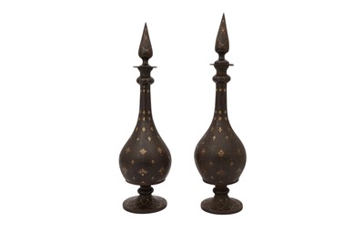 Lot 28 - A NEAR PAIR OF QAJAR GOLD-DAMASCENED STEEL BOTTLES WITH STOPPERS