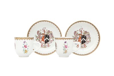Lot 680 - A PAIR OF CHINESE FAMILLE ROSE ARMORIAL CUPS AND SAUCERS.