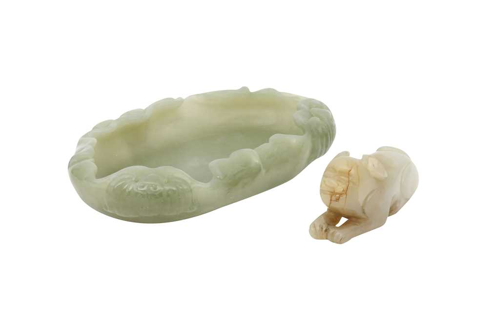 Lot 592 - A CHINESE PALE CELADON JADE 'LEAF' WASHER AND A 'LION DOG' CARVING.