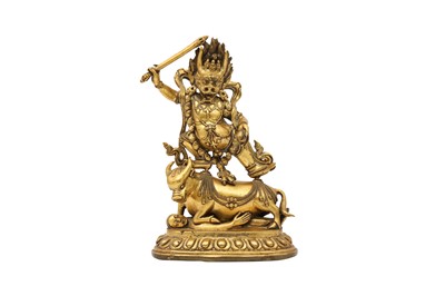 Lot 385 - A SINO-TIBETAN GILT-BRONZE FIGURE OF YAMA DHARMARAJA.