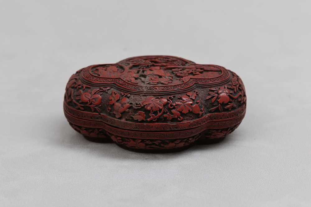 Lot 4 - A CHINESE CINNABAR LACQUER QUATREFOIL BOX AND COVER.