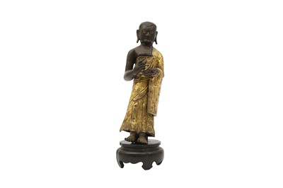 Lot 386 - A CHINESE PARCEL-GILT COPPER ALLOY REPOUSÉE FIGURE OF A MONK.