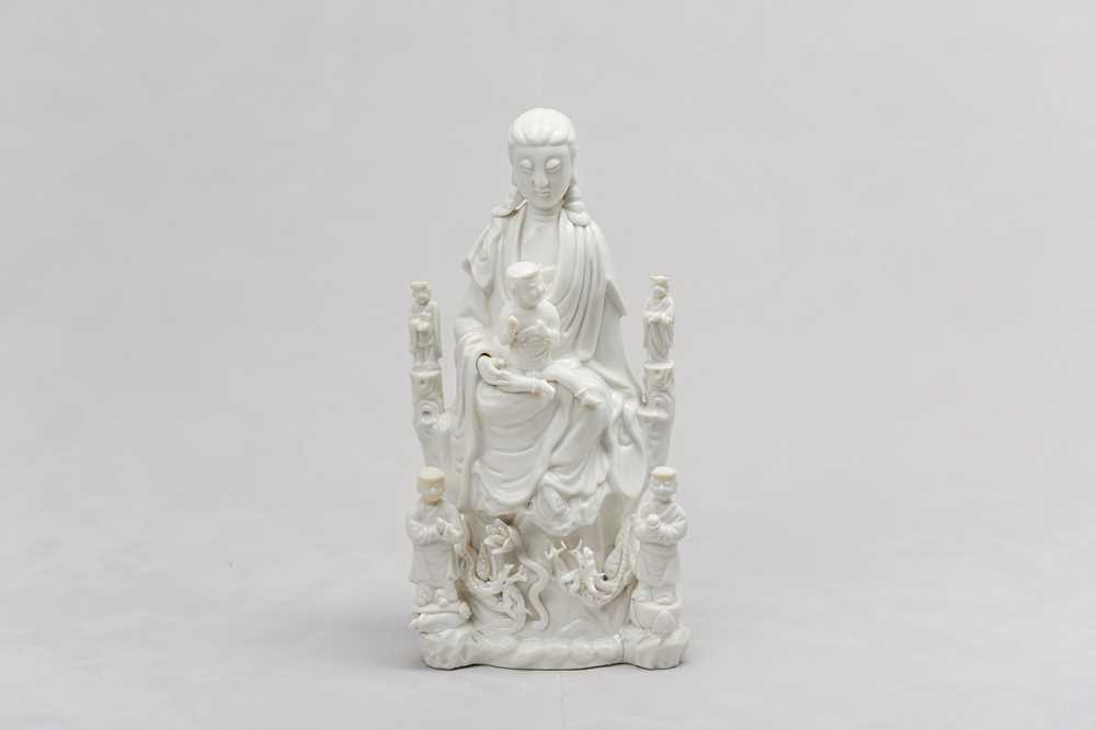 Lot 26 - A CHINESE BLANC-DE-CHINE 'GUANYIN AND CHILD' GROUP.