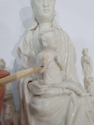 Lot 26 - A CHINESE BLANC-DE-CHINE 'GUANYIN AND CHILD' GROUP.