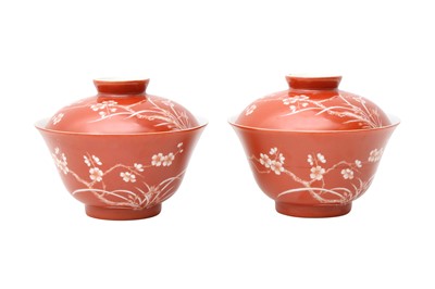 Lot 366 - A PAIR OF CHINESE CORAL-GROUND 'PRUNUS' BOWLS AND COVERS.
