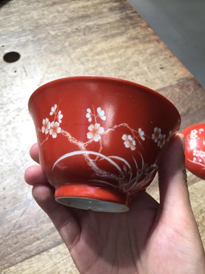 Lot 211 - A PAIR OF CHINESE CORAL-GROUND 'PRUNUS' BOWLS AND COVERS