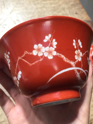 Lot 211 - A PAIR OF CHINESE CORAL-GROUND 'PRUNUS' BOWLS AND COVERS