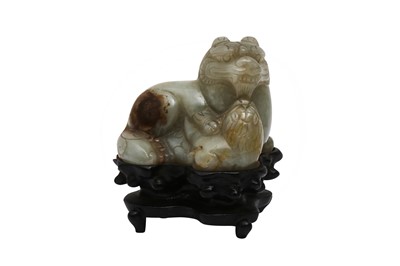 Lot 306 - A CHINESE PALE CELADON JADE CARVING OF A LION DOG AND CALF