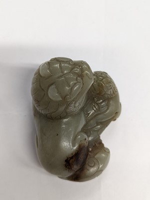 Lot 306 - A CHINESE PALE CELADON JADE CARVING OF A LION DOG AND CALF