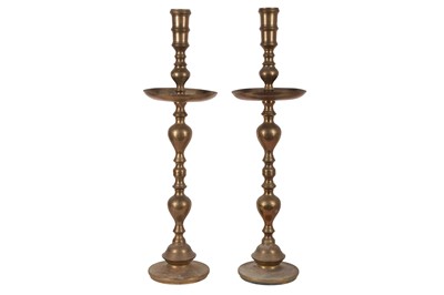 Lot 392 - A PAIR OF EARLY 20TH CENTURY INDIAN BRASS FLOOR-STANDING TEMPLE CANDLESTICKS