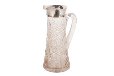 Lot 121 - A GEORGE V CUT GLASS CLARET JUG, WITH A STERLING SILVER RIM