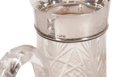 Lot 121 - A GEORGE V CUT GLASS CLARET JUG, WITH A STERLING SILVER RIM