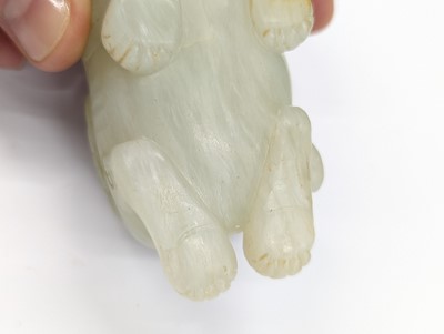 Lot 302 - A CHINESE PALE CELADON JADE CARVING OF A LION DOG
