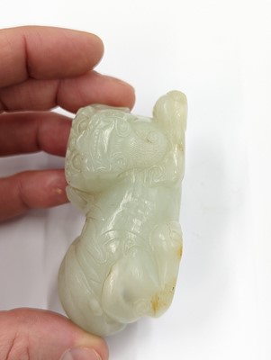 Lot 302 - A CHINESE PALE CELADON JADE CARVING OF A LION DOG