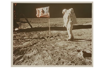 Lot 110 - Buzz Aldrin posing for a photograph beside the US flag