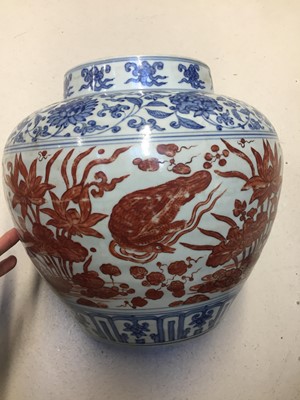 Lot 54 - A CHINESE COPPER RED-ENAMELLED BLUE AND WHITE 'LOTUS POND' JAR