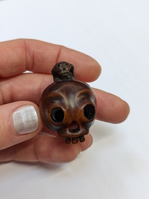 Lot 612 - A JAPANESE WOOD NETSUKE OF A SKULL
