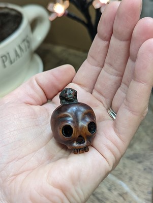 Lot 612 - A JAPANESE WOOD NETSUKE OF A SKULL