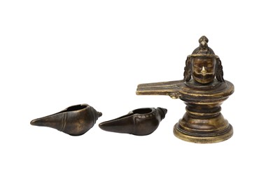 Lot 577 - AN INDIAN BRONZE LINGAM AND YONI AND TWO CONCH SHELL LAMPS