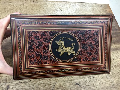 Lot 383 - A BURMESE RED AND BLACK LACQUER 'TIGER' BOX