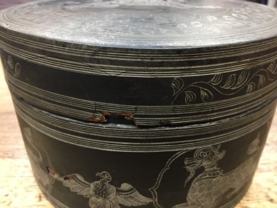 Lot 381 - A BURMESE INCISED BLACK LACQUER 'EQUESTRIAN' BETEL-BOX AND COVER