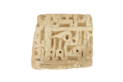 Lot 272 - A MOULDED AND CARVED POTTERY TILE FRAGMENT WITH KUFIC CALLIGRAPHY