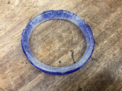 Lot 110 - A CHINESE BLUE-OVERLAY BEIJING GLASS 'CHILONG' BANGLE